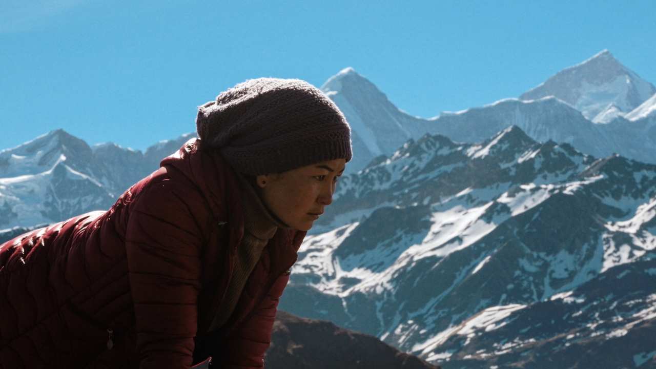a woman in front of snowy mountains